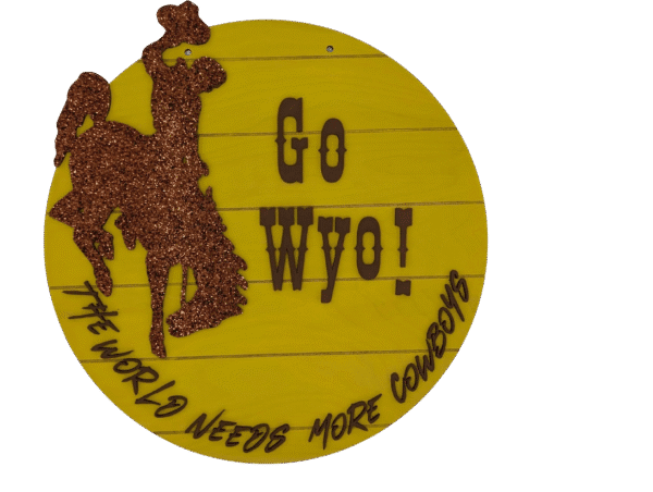 Red Rooster Laser Arts The DIY Door Hanger Kit - University of Wyoming Pride features a round yellow sign with a glittery brown cowboy on a bucking horse and “GO WYO!” plus “THE WORLD NEEDS MORE COWBOYS”—ideal for your next craft project.