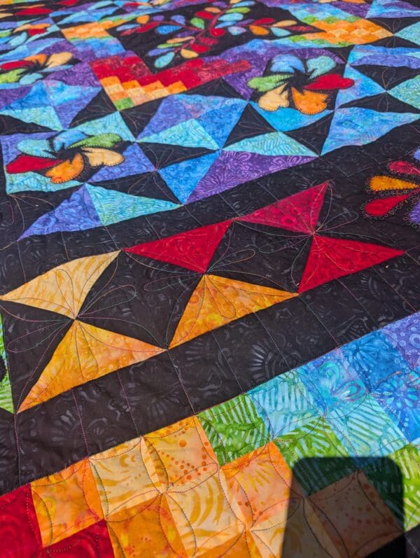 A colorful quilt with many different designs on it.