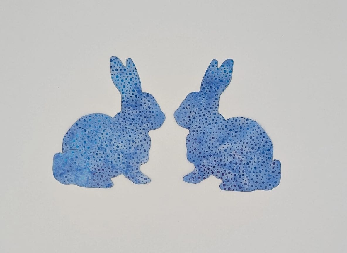 Two blue rabbits sitting next to each other.