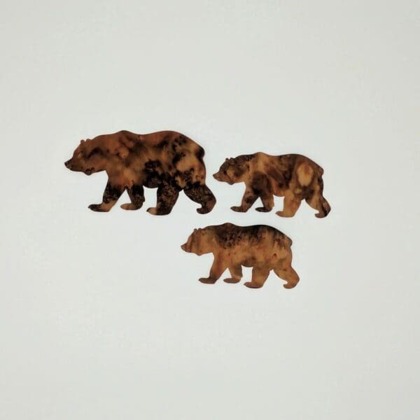 Three bears are standing on a white surface.