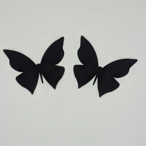 A pair of black butterflies on a white wall.