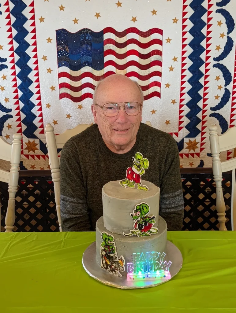 A man sitting at the table with a cake