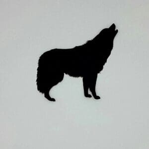 A silhouette of a wolf standing on top of a white wall.