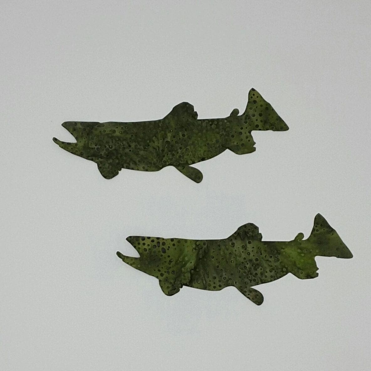 Two fish made of seaweed are shown on a white surface.