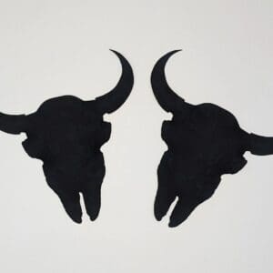 A pair of black cow skulls on the wall.