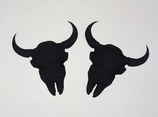 A pair of black cow skulls on the wall.