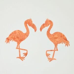 A pair of flamingos are standing next to each other.