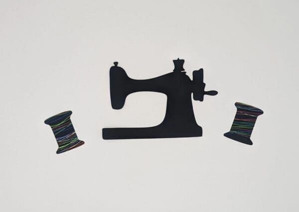 A black sewing machine and two spools of thread.