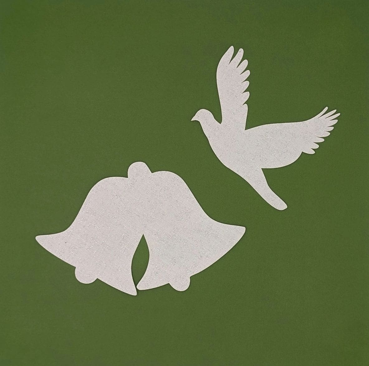 A white bird and two bells on a green background