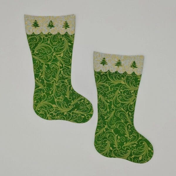 Two green christmas stockings with trees on them.