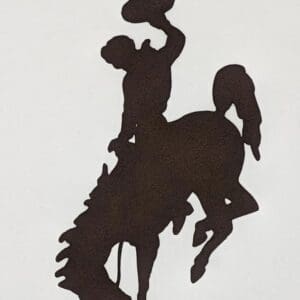 A silhouette of a cowboy riding on the back of a horse.