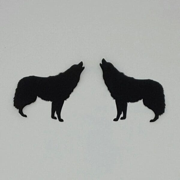 A pair of black wolf earrings on white background.