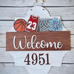 Red Rooster Laser Arts Enhance your decor with the Basketball Interchangeable Door Hanger Insert featuring a red jersey #23, blue pom-poms, and a net on a wooden background displaying Welcome 4951, ideal for sports enthusiasts. This is a diy laser cut kit.