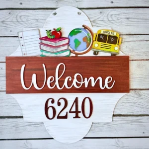 Red Rooster Laser Arts The Interchangeable Door Hanger Insert - Back to School features Welcome 6240 text and displays a globe, school bus, stacked books with an apple, and notebook paper on a light wooden background—ideal for creating an inviting educational atmosphere.