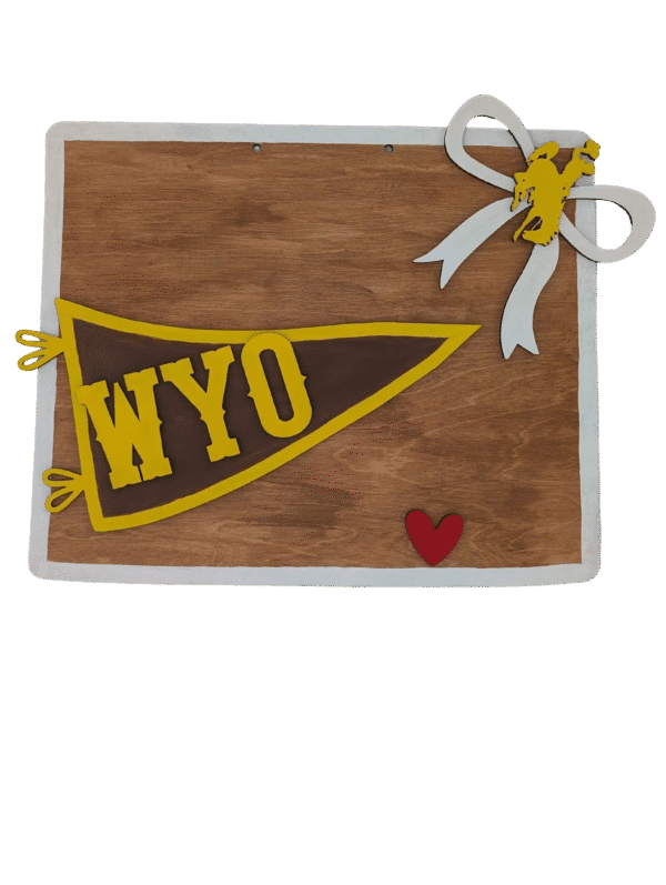 Red Rooster Laser Arts The DIY Door Hanger Kit - Wyoming State features a wooden board with a yellow WYO pennant, white ribbon with a yellow bucking horse, and a small red heart on the lower right. A gray background makes this charming décor stand out.