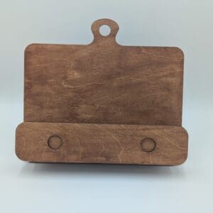 Red Rooster Laser Arts A wooden stand with a rectangular back, a rounded handle at the top, and a horizontal base with two circular indents—perfect as an insert only for your favorite cookbook holder or to display cookies for Santa. Set against a plain light background.