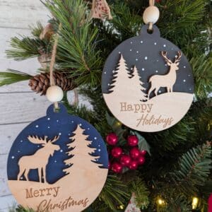 Red Rooster Laser Arts The Woodland Holiday Ornament Set – Pre-Finished & Assembled Wooden Christmas Collection (Set of 2) features one ornament with a moose and “Merry Christmas,” and another with a deer and “Happy Holidays” for festive tree décor.