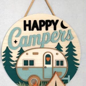 Red Rooster Laser Arts The DIY Door Hanger Kit - "Happy Campers 1" is a round wooden sign with a camper van, tent, pine trees, campfire, and crescent moon design. It features "Happy Campers" text and hangs by rope on a light wall.
