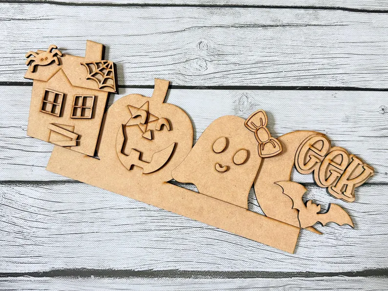 Red Rooster Laser Arts Pair your haunted house, jack-o-lantern, bow-tied ghost, “EEK” sign, and bat wooden Halloween decorations—all set against a light wooden background—with the Interchangeable Door Hanger Insert - Thanksgiving Harvest to easily transition your decor from spooky season to festive autumn celebrations.