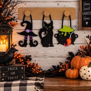 Red Rooster Laser Arts The DIY Interchangeable Wall Peg System Decor - Witchy Halloween features a rustic wooden background with a creative display: interchangeable pieces including a witch hat, black cat, and bubbling cauldron that hang on hooks. The scene is enhanced with pumpkins, berries, a candle lantern, a crow, and festive signs for the perfect spooky touch.
