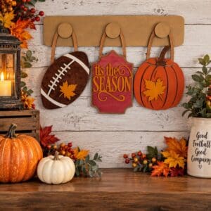 Red Rooster Laser Arts Bring the spirit of autumn and football season into your home with the DIY Interchangeable Wall Peg System Decor – Fall Football, featuring a football, “Tis the Season” sign, and pumpkin on a wooden wall, surrounded by fall leaves, pumpkins, lanterns, and a jar labeled “Good Football Good Company”—the perfect way to celebrate Fall and Football in style with customizable decor!.